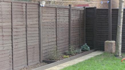 Painting of fence and border decking in dark oak